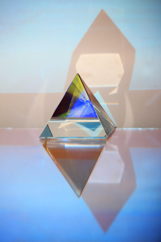 Un prisma separa i colori della luce. Immagine di copertina della mostra: SENSIBILE È LA CHIARA LUCE di Mya Lurgo